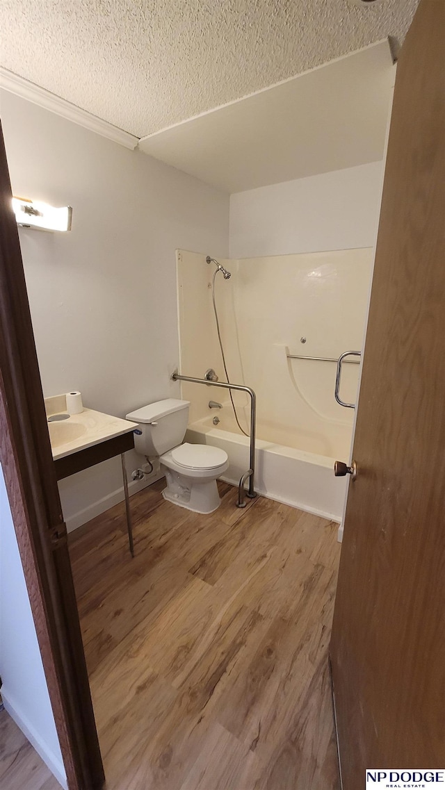 full bathroom with vanity, shower / bath combination, a textured ceiling, toilet, and hardwood / wood-style flooring