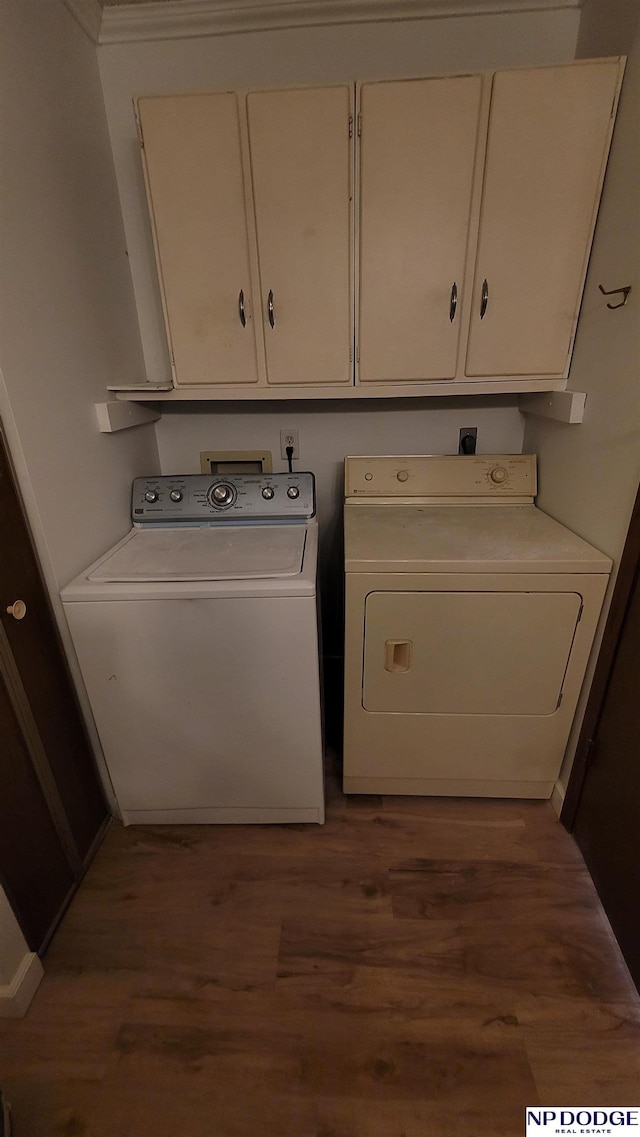 laundry area with separate washer and dryer, dark hardwood / wood-style floors, and cabinets