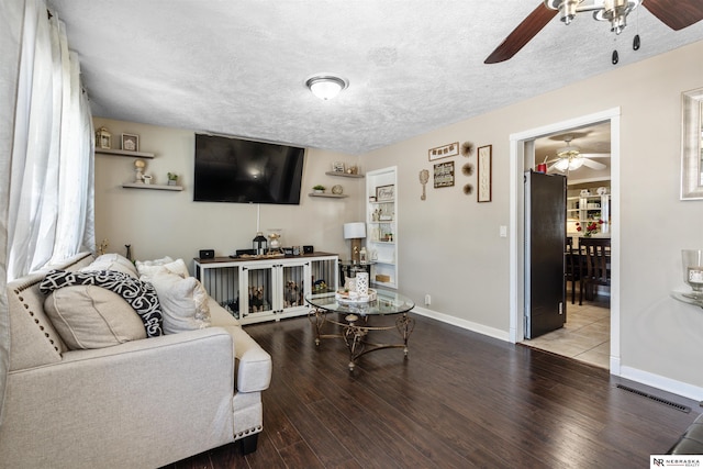 living room with a textured ceiling, hardwood / wood-style flooring, and ceiling fan