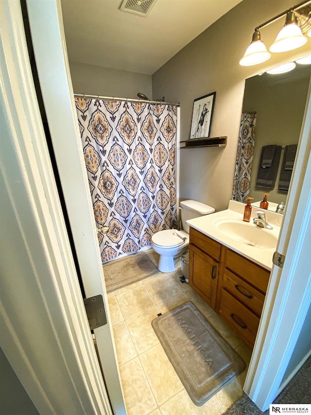 bathroom featuring toilet, vanity, and tile patterned flooring