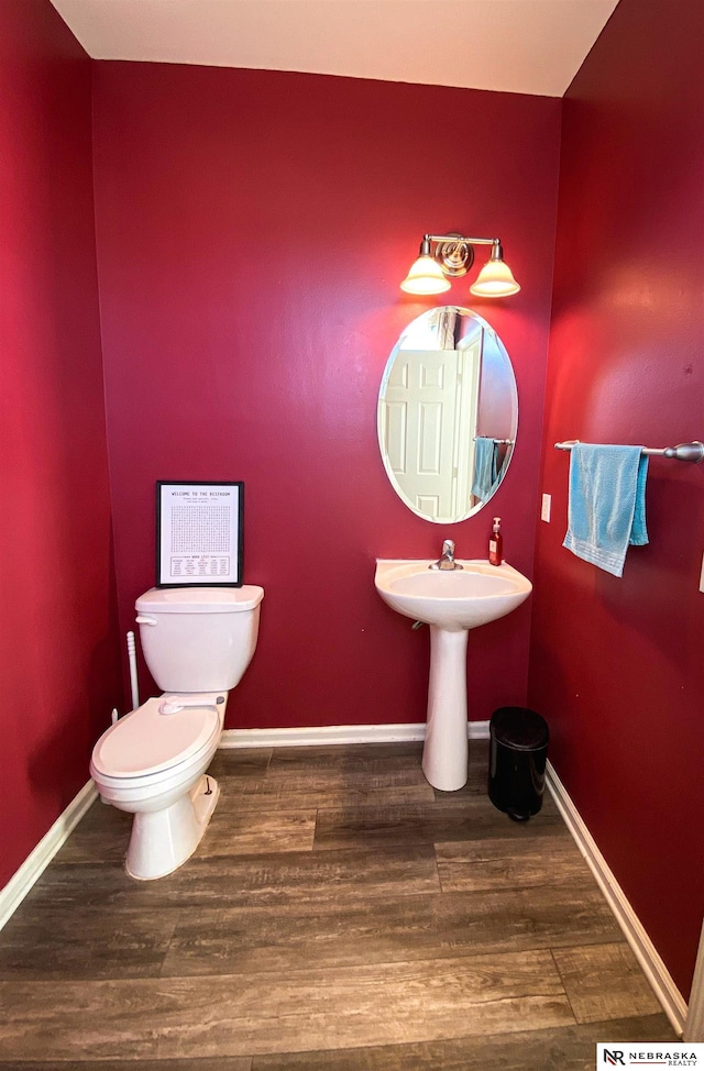 bathroom with toilet and hardwood / wood-style flooring