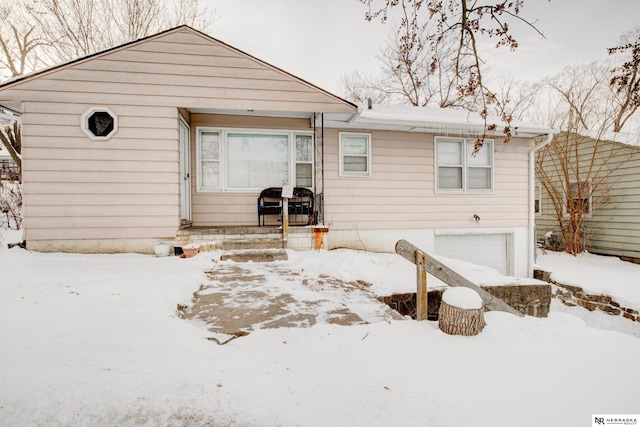 snow covered property featuring a garage