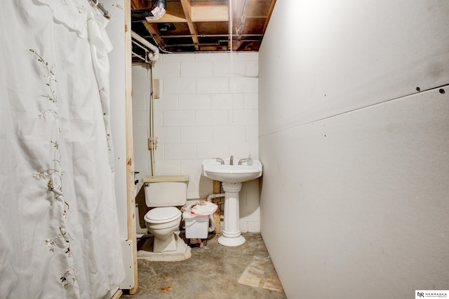 bathroom featuring sink, concrete flooring, and toilet