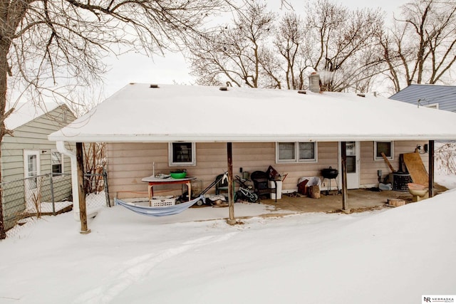 view of snow covered back of property