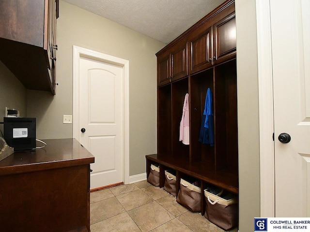 mudroom with light tile patterned floors and a textured ceiling