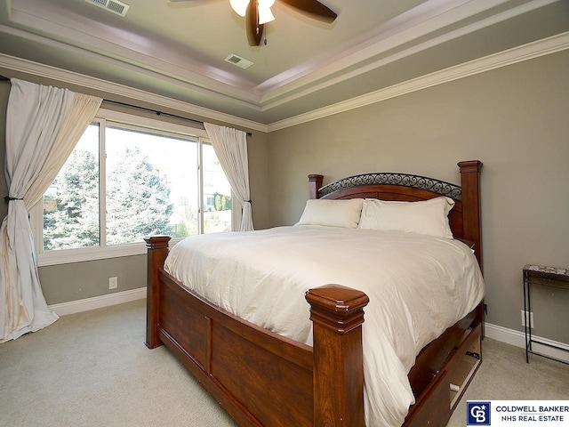 carpeted bedroom featuring a tray ceiling, ornamental molding, and ceiling fan