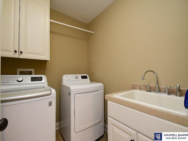 washroom with cabinets, washer and clothes dryer, a textured ceiling, and sink