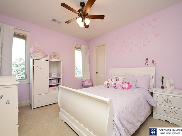 carpeted bedroom featuring multiple windows and ceiling fan