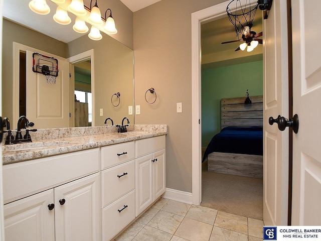 bathroom with ceiling fan with notable chandelier and vanity