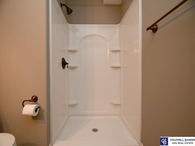 bathroom featuring toilet and walk in shower