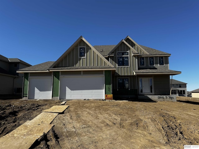 view of front of house with board and batten siding, driveway, and an attached garage