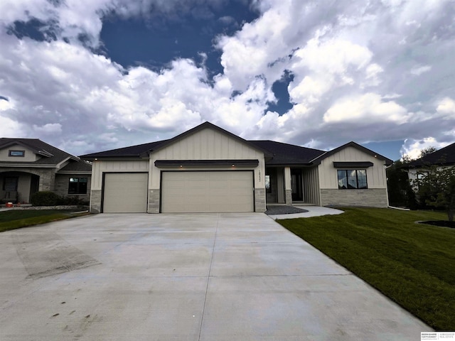 view of front of house featuring a garage, stone siding, board and batten siding, and a front yard