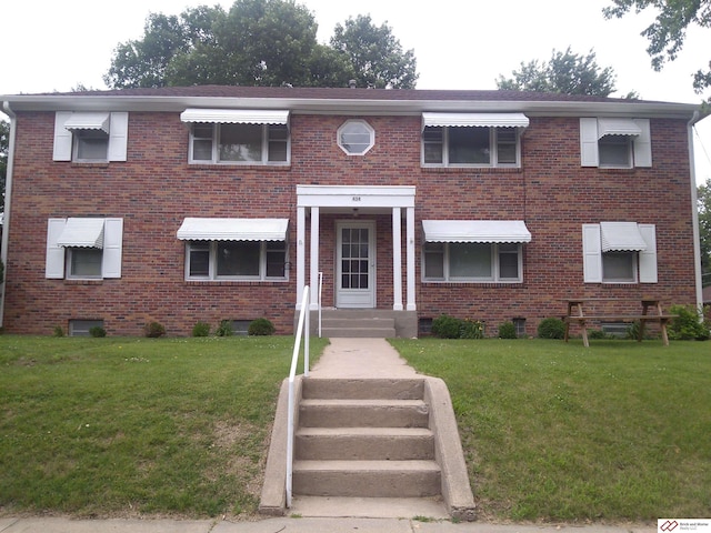 view of front of home featuring brick siding and a front yard