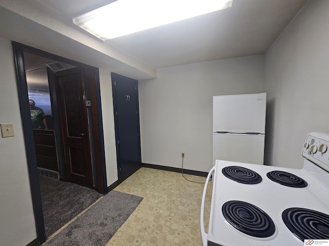 kitchen with white appliances, light floors, and baseboards
