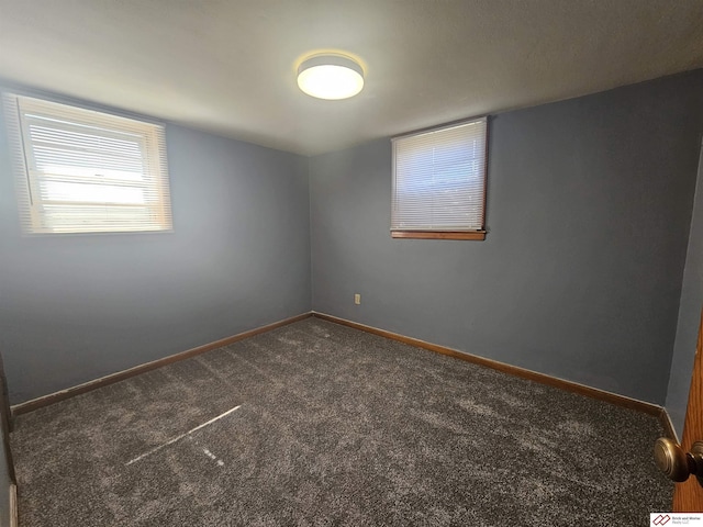 carpeted empty room featuring baseboards