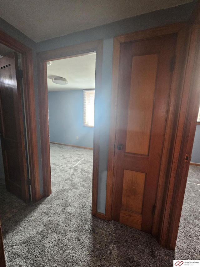 corridor featuring carpet flooring and baseboards