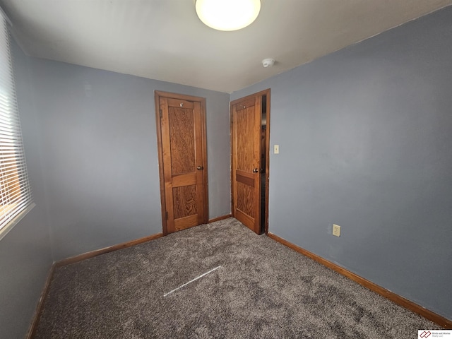unfurnished room featuring baseboards and carpet flooring