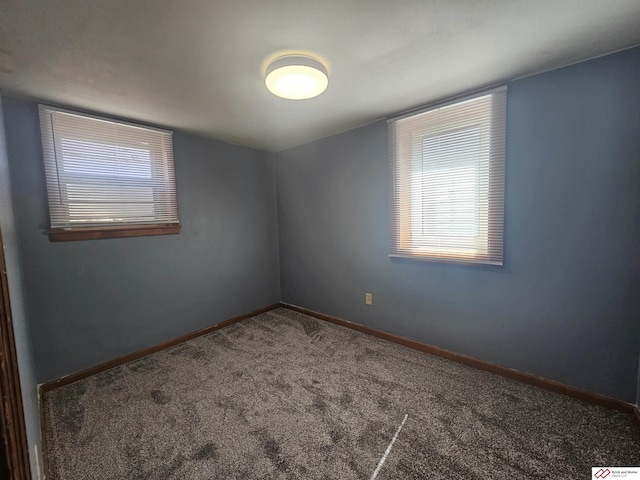 carpeted spare room with baseboards