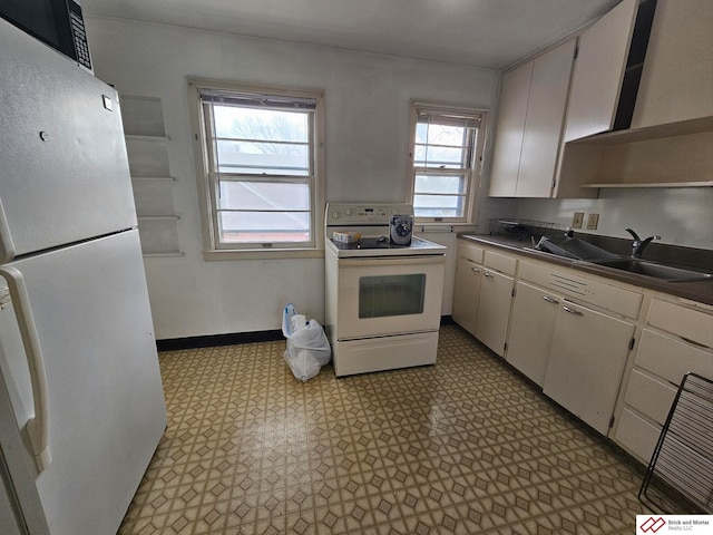 kitchen featuring white appliances, light floors, baseboards, open shelves, and a sink