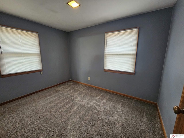 spare room with carpet and baseboards