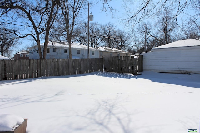 snowy yard featuring fence