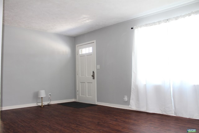 entrance foyer with baseboards, dark wood finished floors, and a textured ceiling