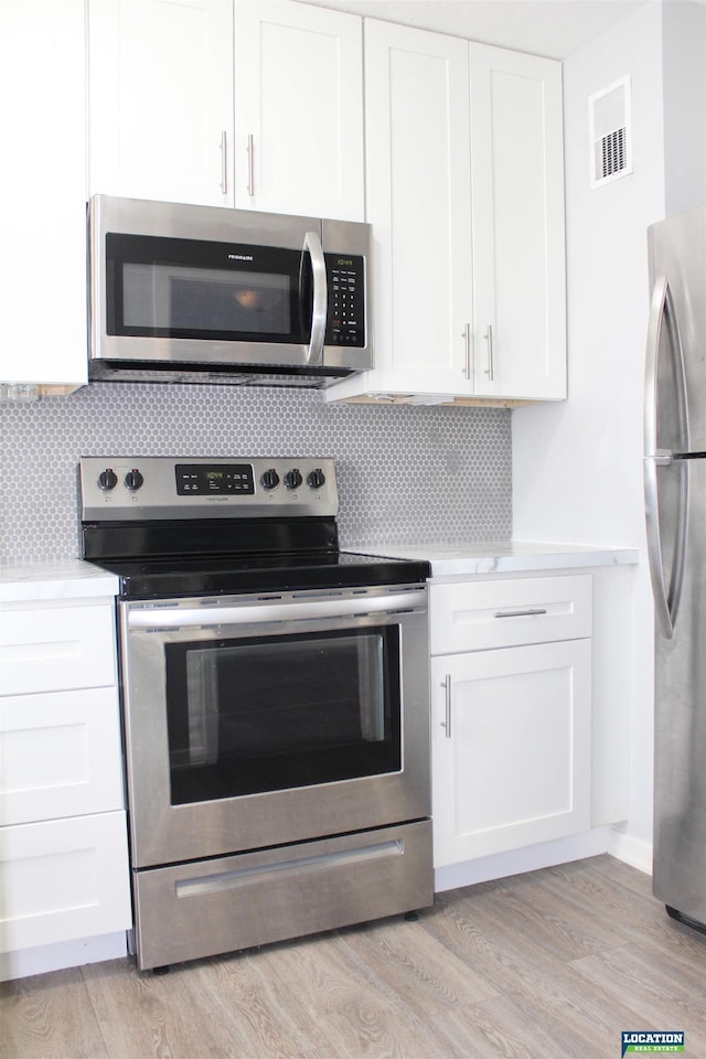 kitchen with light countertops, appliances with stainless steel finishes, and white cabinets