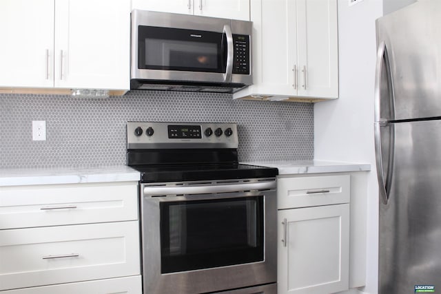 kitchen with stainless steel appliances, white cabinetry, and tasteful backsplash