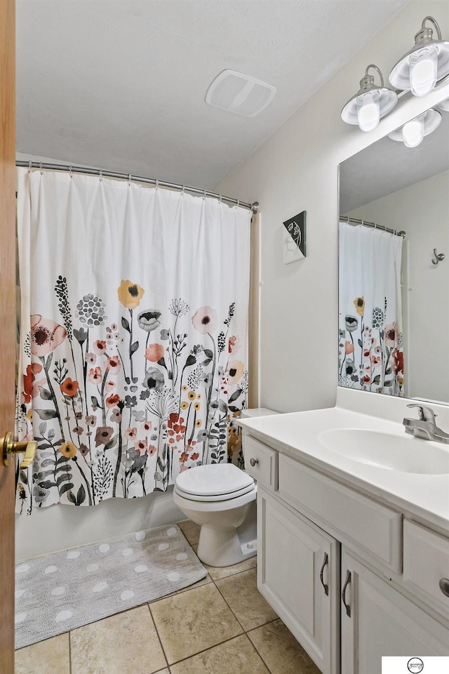 bathroom featuring toilet, vanity, tile patterned flooring, and walk in shower