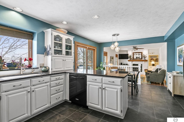 kitchen with sink, white cabinetry, hanging light fixtures, and kitchen peninsula