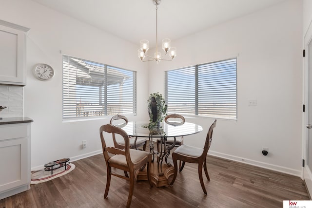 dining room with baseboards, a chandelier, and dark wood finished floors