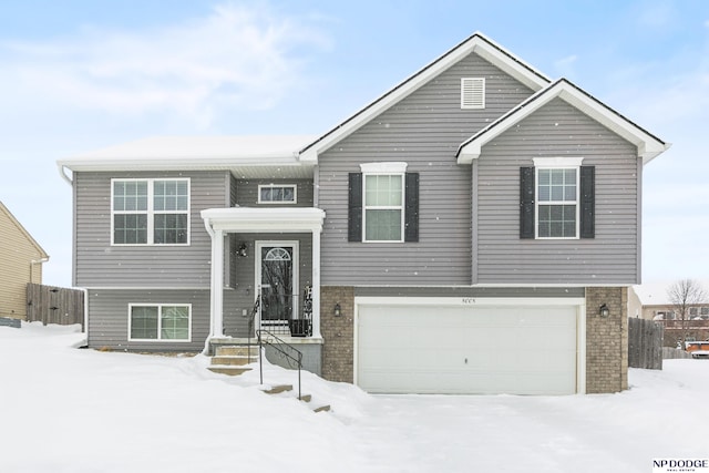 raised ranch featuring brick siding and a garage