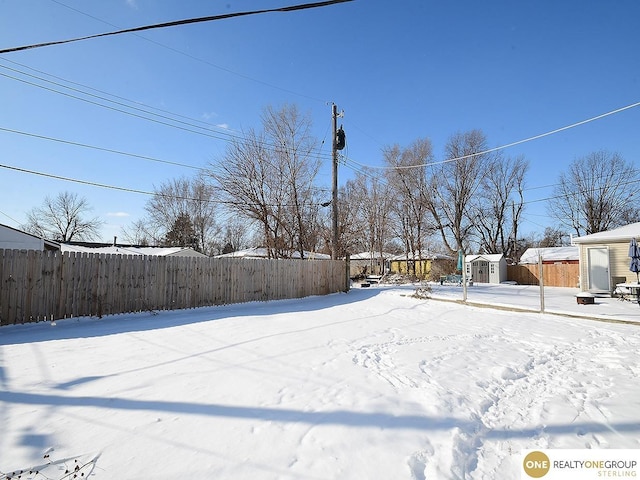 snowy yard with a storage unit