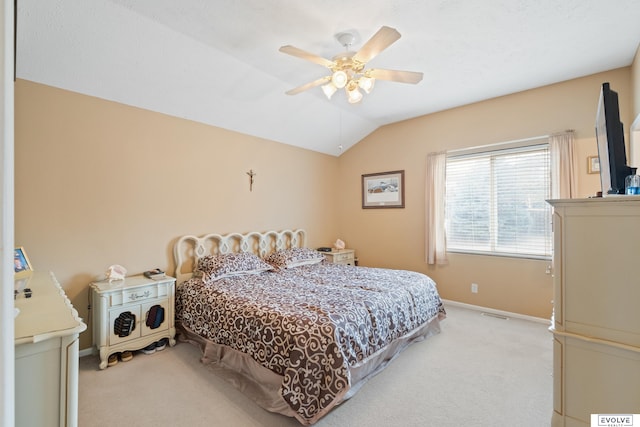 bedroom featuring a ceiling fan, baseboards, light carpet, and vaulted ceiling