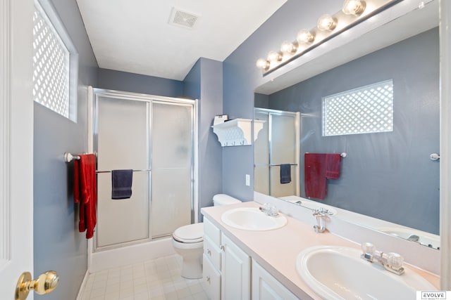 bathroom with a shower stall, toilet, visible vents, and a sink