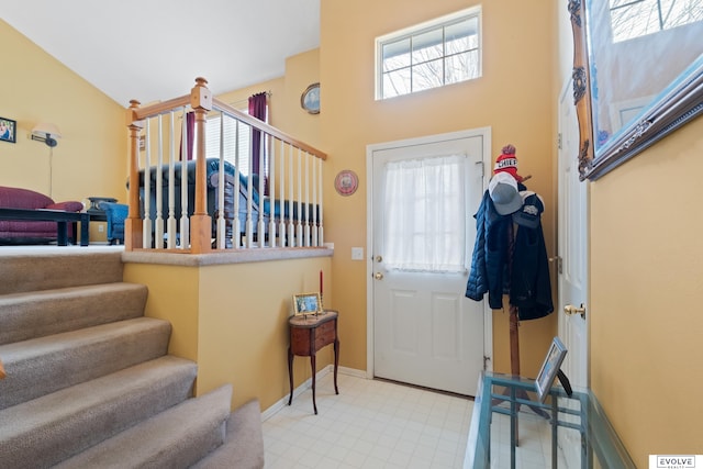 entryway featuring baseboards, plenty of natural light, and stairway