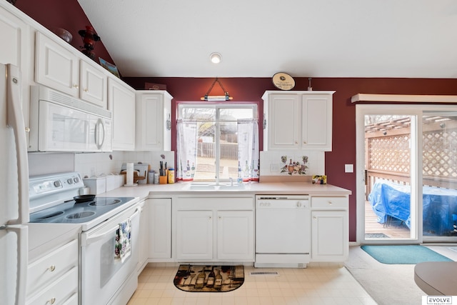 kitchen with decorative backsplash, vaulted ceiling, light countertops, white appliances, and white cabinets