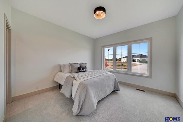 bedroom featuring baseboards, visible vents, and light colored carpet