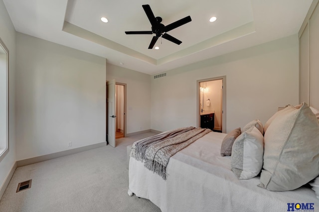 bedroom with baseboards, a raised ceiling, and visible vents