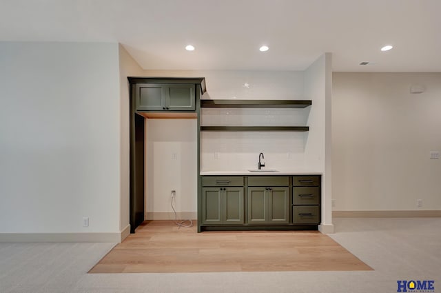 bar featuring baseboards, visible vents, recessed lighting, a sink, and light wood-style floors