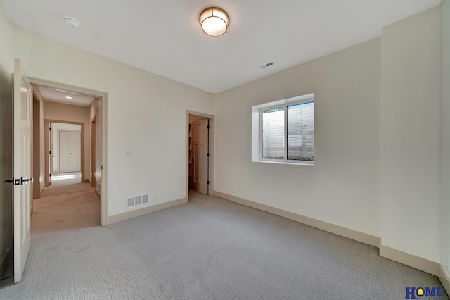 unfurnished bedroom with baseboards, visible vents, and light carpet