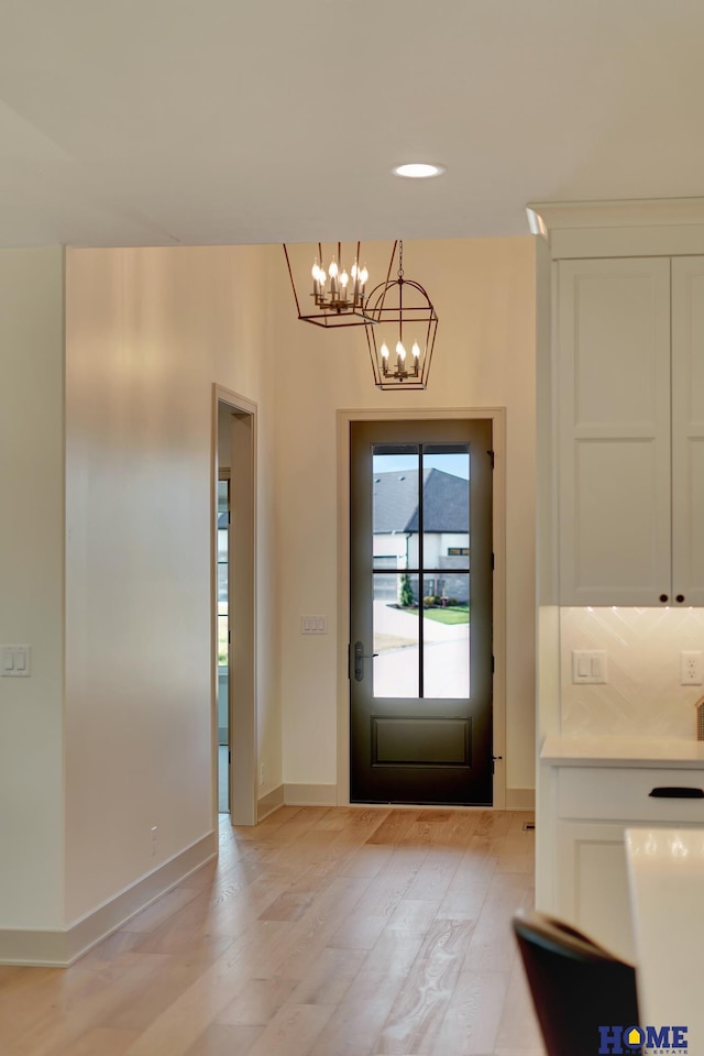 entrance foyer featuring light wood-type flooring, recessed lighting, baseboards, and a notable chandelier