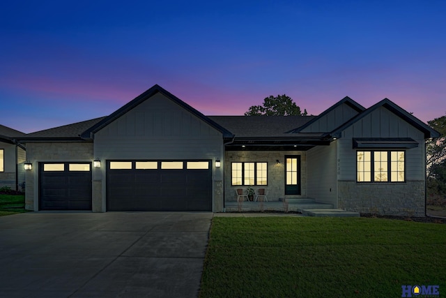 modern inspired farmhouse with stone siding, a yard, board and batten siding, driveway, and an attached garage