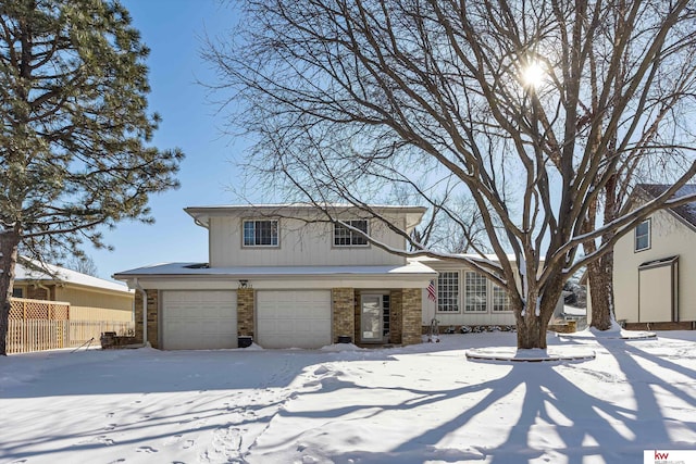 view of front of house featuring a garage, brick siding, and fence