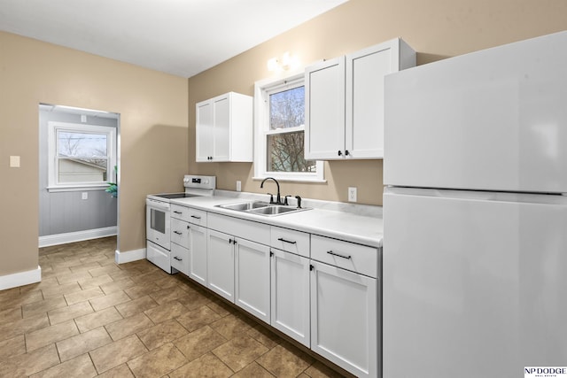 kitchen featuring a sink, white cabinetry, light countertops, and white appliances