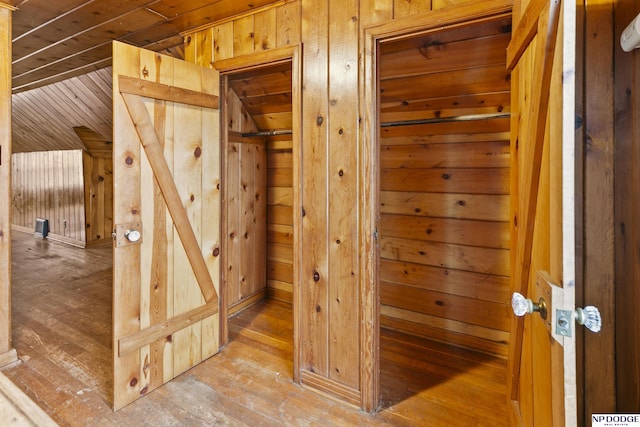 interior space with light wood-style flooring and wood walls