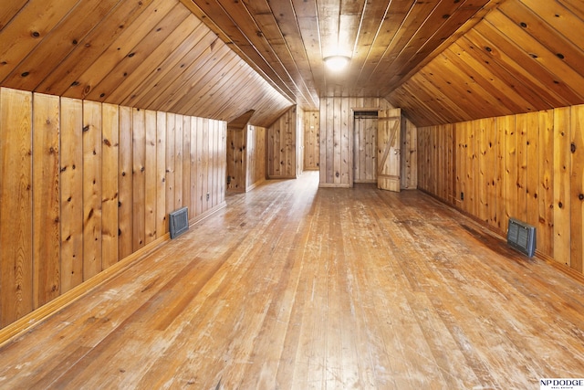 bonus room featuring wood ceiling, visible vents, wood finished floors, and wooden walls