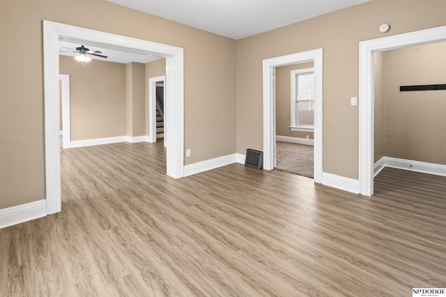 spare room with ceiling fan, baseboards, light wood-style floors, and visible vents