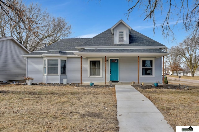 view of front of home with a porch, a front yard, and a shingled roof