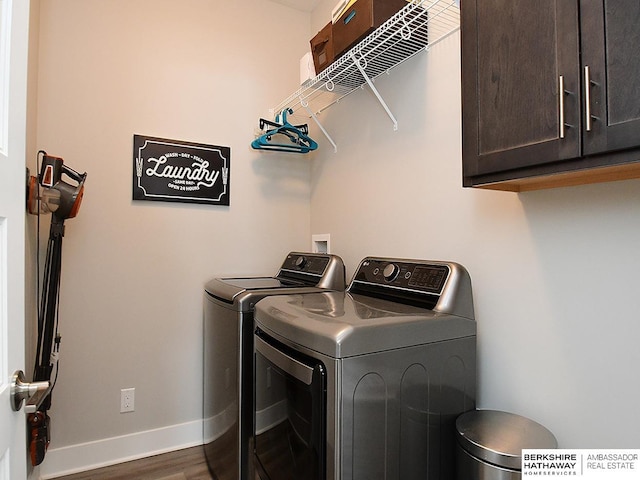 washroom with dark wood-type flooring, washing machine and dryer, cabinet space, and baseboards